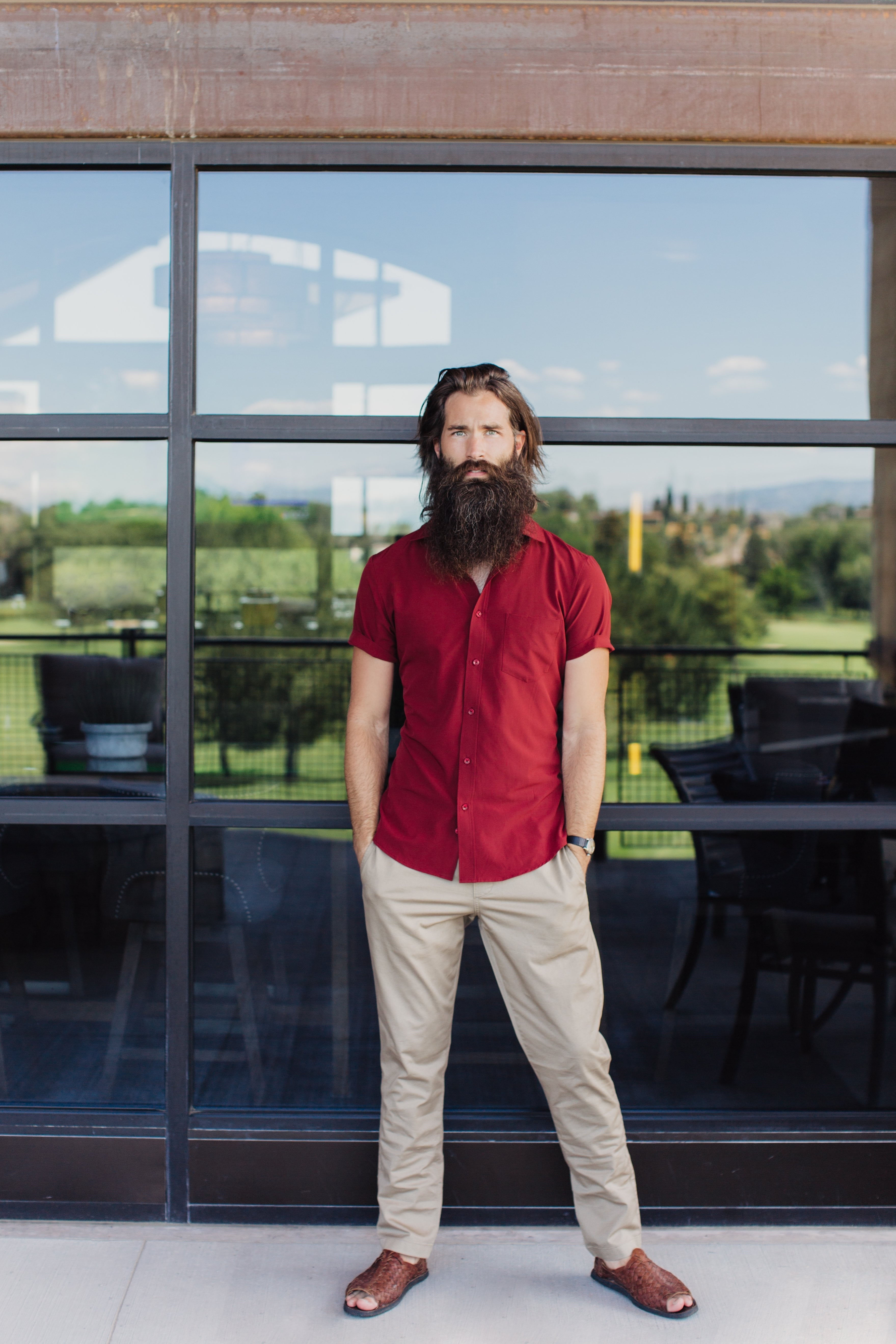 Bearded man in Truwear red shirt, brown dress pants, and sandals